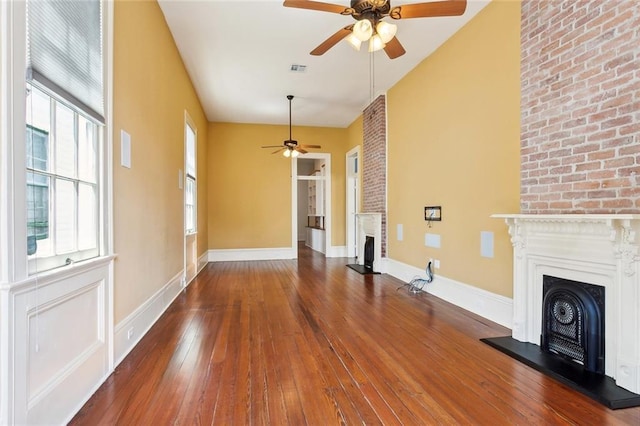 3119 Dauphine St, New Orleans, LA 70117 - unfurnished living room featuring a fireplace with raised hearth, ceiling fan, and hardwood / wood-style floors