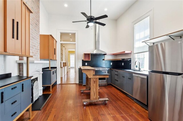 3119 Dauphine St, New Orleans, LA 70117 - kitchen with appliances with stainless steel finishes, wall chimney range hood, ceiling fan, dark wood-style flooring, and recessed lighting