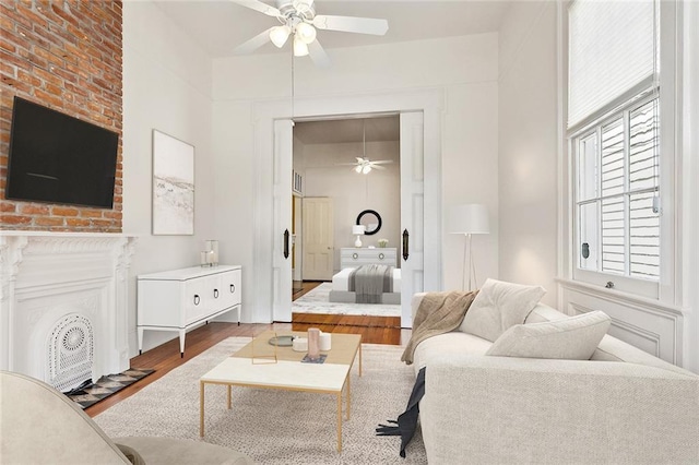 3119 Dauphine St, New Orleans, LA 70117 - living area featuring a ceiling fan, wood finished floors, and a fireplace