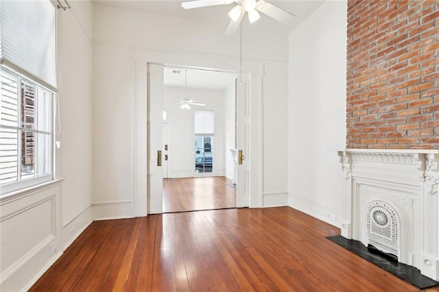 3119 Dauphine St, New Orleans, LA 70117 - unfurnished living room with ceiling fan, hardwood / wood-style flooring, and a fireplace