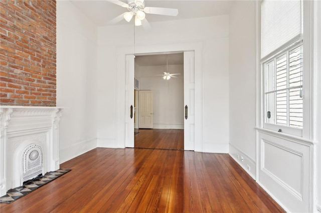 3119 Dauphine St, New Orleans, LA 70117 - unfurnished living room featuring ceiling fan, hardwood / wood-style flooring, and a fireplace
