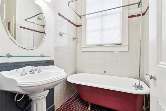 3119 Dauphine St, New Orleans, LA 70117 - full bathroom featuring a soaking tub, tile walls, and tile patterned floors