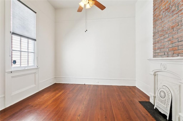 3119 Dauphine St, New Orleans, LA 70117 - spare room featuring dark wood-style floors, ceiling fan, and a fireplace with flush hearth