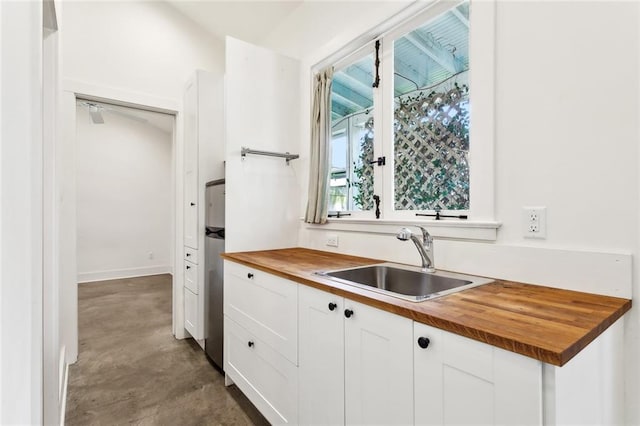 3119 Dauphine St, New Orleans, LA 70117 - kitchen with butcher block countertops, finished concrete floors, and white cabinets