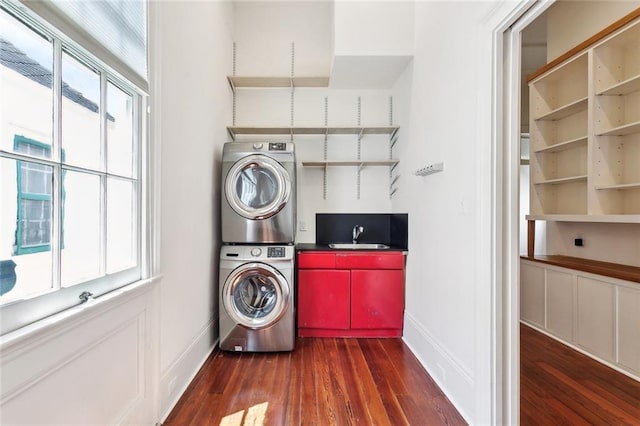 3119 Dauphine St, New Orleans, LA 70117 - washroom featuring stacked washer and clothes dryer and wood finished floors