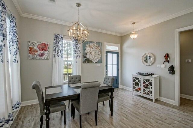61113 Jade St, Lacombe, LA 70445 - dining room with wood finished floors, baseboards, ornamental molding, and a chandelier