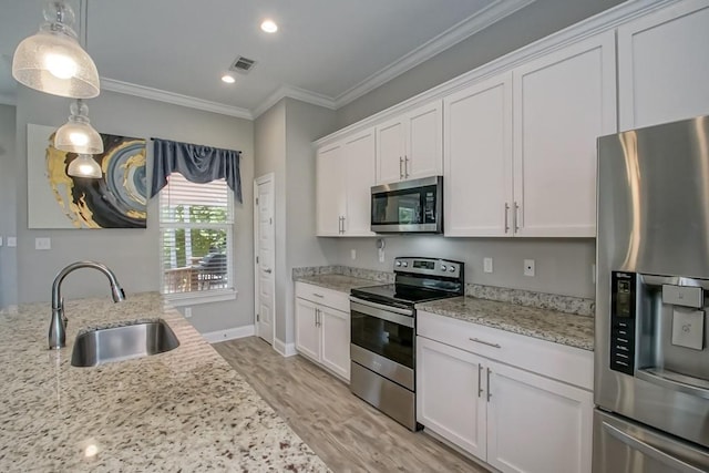 61113 Jade St, Lacombe, LA 70445 - kitchen featuring stainless steel appliances, a sink, white cabinets, light wood-style floors, and ornamental molding