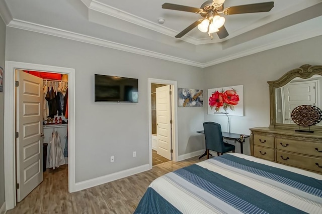 61113 Jade St, Lacombe, LA 70445 - bedroom featuring a raised ceiling, a walk in closet, wood finished floors, crown molding, and a closet