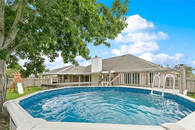 4740 Red Oak Dr, Marrero, LA 70072 - view of pool with a fenced backyard and a playground