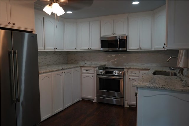 24819 S Walker Rd, Denham Springs, LA 70726 - kitchen with stainless steel appliances, a sink, dark wood-style flooring, tasteful backsplash, and a ceiling fan