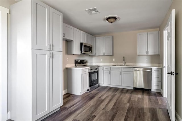 3417 W Louisiana State Dr, Kenner, LA 70065 - kitchen featuring appliances with stainless steel finishes, a sink, light countertops, dark wood finished floors, and baseboards