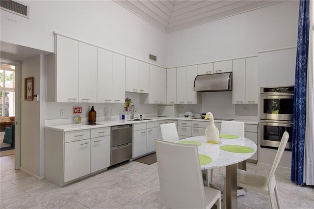 1450 Pine Tree Rd, Opelousas, LA 70570 - kitchen featuring under cabinet range hood, appliances with stainless steel finishes, a sink, a high ceiling, and light countertops