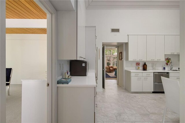 1450 Pine Tree Rd, Opelousas, LA 70570 - kitchen with dishwasher, white cabinets, light countertops, a sink, and light marble finish flooring