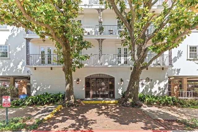 1765 Coliseum St Unit 303, New Orleans, LA 70130 - view of front of property featuring a balcony, french doors, and brick siding