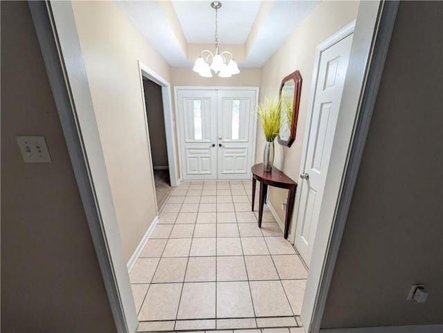 608 Eagle Dr, Slidell, LA 70461 - doorway to outside featuring a chandelier, light tile patterned floors, a raised ceiling, and baseboards