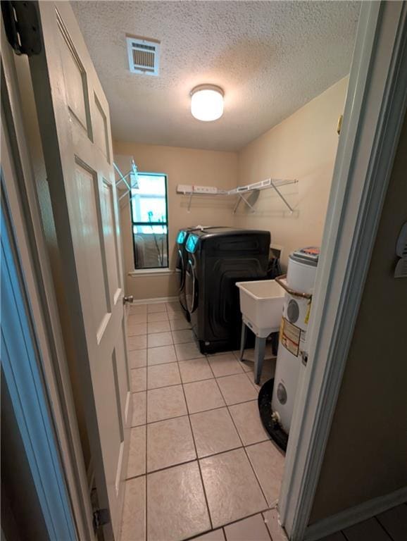 608 Eagle Dr, Slidell, LA 70461 - laundry area with a textured ceiling, light tile patterned floors, washing machine and dryer, and baseboards