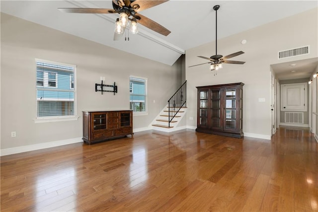 4027 Borneo St, Bay Saint Louis, MS 39520 - unfurnished living room featuring a ceiling fan, stairway, wood finished floors, and high vaulted ceiling