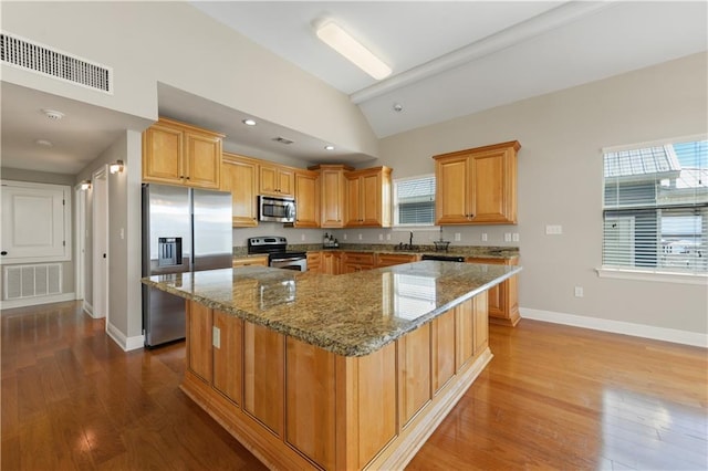 4027 Borneo St, Bay Saint Louis, MS 39520 - kitchen with appliances with stainless steel finishes, stone counters, lofted ceiling, dark wood-style flooring, and a kitchen island