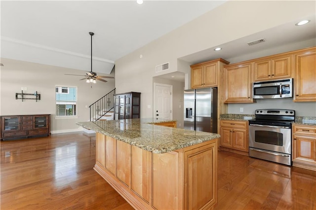 4027 Borneo St, Bay Saint Louis, MS 39520 - kitchen featuring stainless steel appliances, wood finished floors, a center island, light stone counters, and recessed lighting