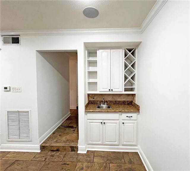 4508 Hessmer Ave, Metairie, LA 70002 - bar with baseboards, a sink, crown molding, tasteful backsplash, and stone tile floors