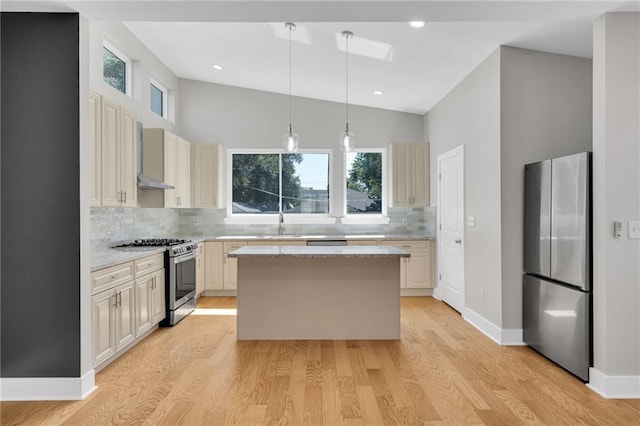 6100 Duplessis St, New Orleans, LA 70122 - kitchen featuring appliances with stainless steel finishes, decorative backsplash, a sink, a kitchen island, and light wood-style flooring
