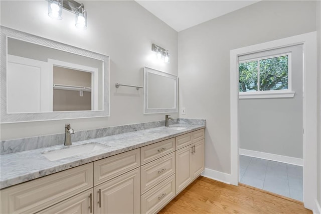 6100 Duplessis St, New Orleans, LA 70122 - full bath with double vanity, baseboards, and wood finished floors