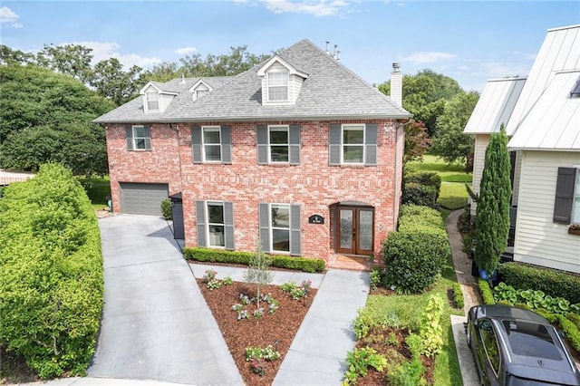 8 Ani St, New Orleans, LA 70124 - view of front facade with concrete driveway, brick siding, a garage, and french doors