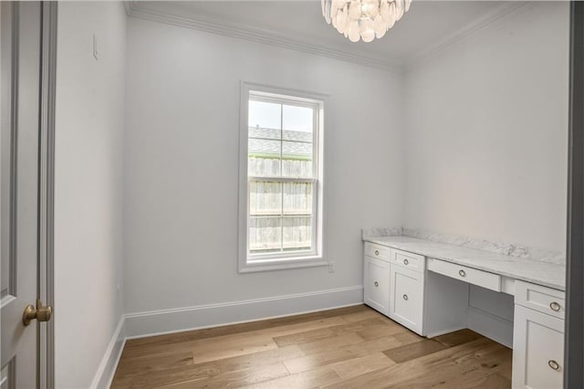 7331 Onyx St, New Orleans, LA 70124 - unfurnished office featuring light wood-style floors, crown molding, baseboards, built in desk, and a chandelier