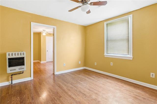3309 4th St, New Orleans, LA 70125 - unfurnished room featuring heating unit, ceiling fan, wood finished floors, and baseboards