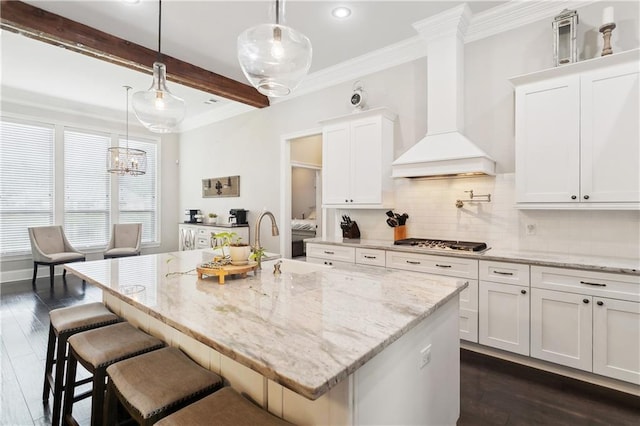 1112 Safflower Ct, Madisonville, LA 70447 - kitchen with custom exhaust hood, a sink, stainless steel gas cooktop, dark wood-style floors, and ornamental molding