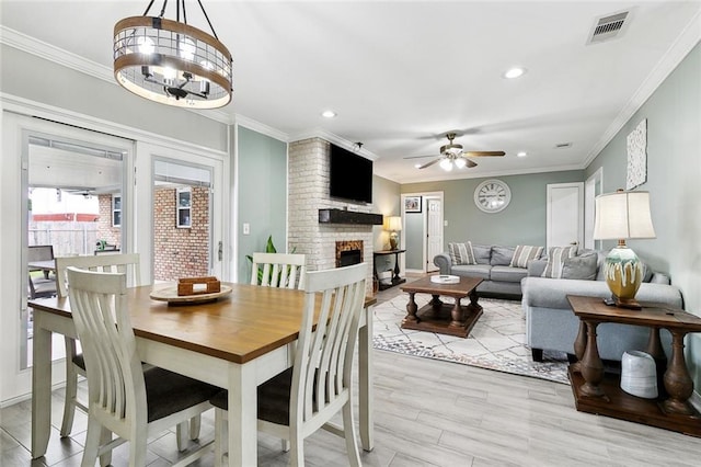 9 Osborne Ave, Kenner, LA 70065 - dining room with a brick fireplace, a ceiling fan, recessed lighting, ornamental molding, and a chandelier