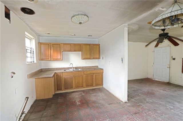 8018 Mackenzie St, New Orleans, LA 70128 - kitchen with a sink, a ceiling fan, brown cabinetry, and light countertops