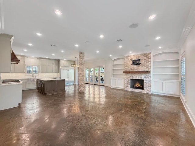 9125 5th St, River Ridge, LA 70123 - unfurnished living room with plenty of natural light, ornamental molding, built in features, recessed lighting, and a brick fireplace