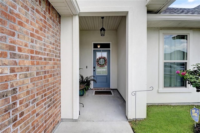 229 Louisiana Iris Cir, Slidell, LA 70458 - view of exterior entry featuring brick siding, stucco siding, and roof with shingles