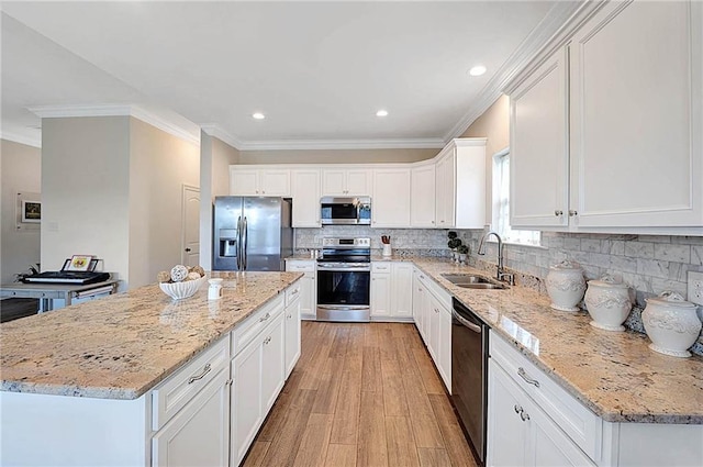 229 Louisiana Iris Cir, Slidell, LA 70458 - kitchen with appliances with stainless steel finishes, a sink, light wood-style floors, white cabinetry, and crown molding