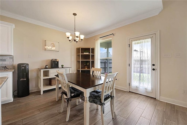 229 Louisiana Iris Cir, Slidell, LA 70458 - dining area with wood finished floors, crown molding, a chandelier, and baseboards