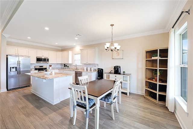 229 Louisiana Iris Cir, Slidell, LA 70458 - dining space featuring light wood-style floors, a chandelier, ornamental molding, baseboards, and recessed lighting