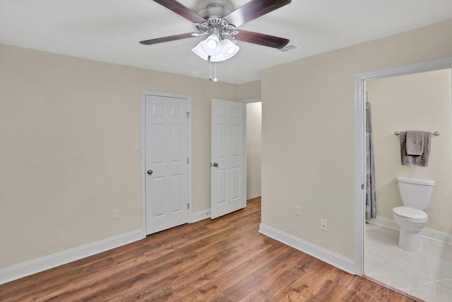314 E Pineridge St Unit 314, Mandeville, LA 70448 - unfurnished bedroom featuring wood finished floors, baseboards, connected bathroom, and a ceiling fan