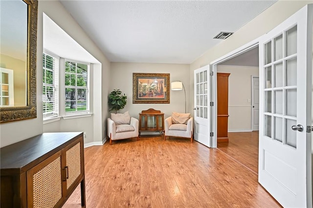 1532 Broadmoor Dr, Slidell, LA 70458 - living area with french doors, light wood finished floors, and baseboards