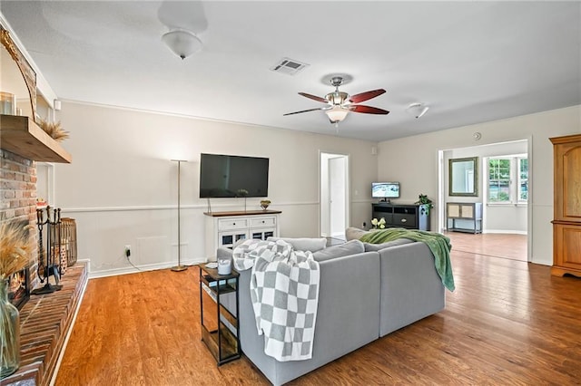 1532 Broadmoor Dr, Slidell, LA 70458 - living area with a fireplace, ceiling fan, light wood finished floors, and baseboards