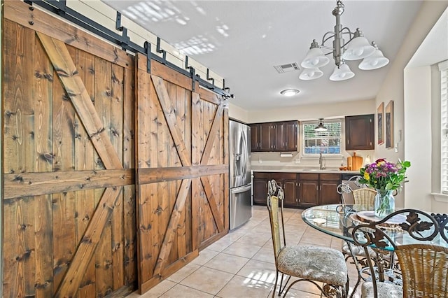 1532 Broadmoor Dr, Slidell, LA 70458 - dining area featuring a barn door, light tile patterned flooring, and a chandelier