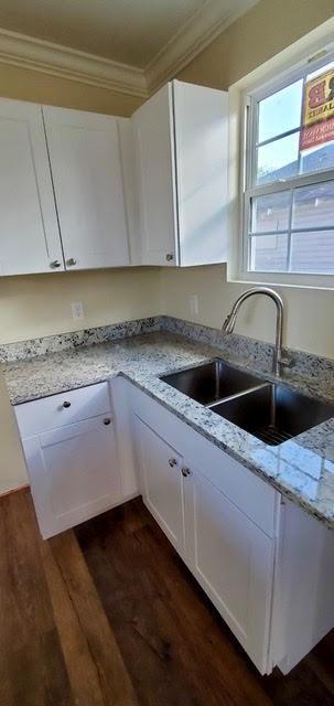921 Andry St, New Orleans, LA 70117 - kitchen featuring crown molding, a sink, dark wood finished floors, and white cabinets