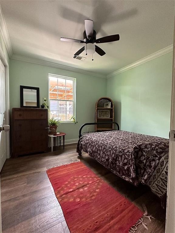 921 Andry St, New Orleans, LA 70117 - bedroom with wood finished floors, ornamental molding, ceiling fan, and baseboards