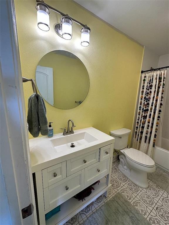 921 Andry St, New Orleans, LA 70117 - full bathroom featuring toilet, vanity, tile patterned flooring, and shower / bath combination with curtain