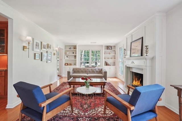 42 Riverdale Dr, Covington, LA 70433 - living room with a lit fireplace, light wood-style flooring, built in shelves, ornamental molding, and baseboards