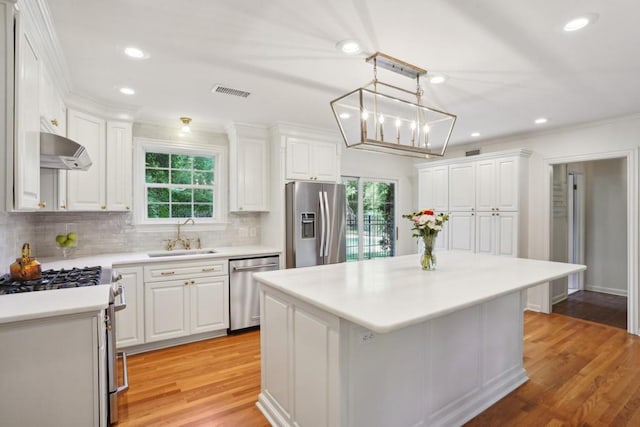 42 Riverdale Dr, Covington, LA 70433 - kitchen featuring a sink, stainless steel appliances, white cabinets, ornamental molding, and recessed lighting