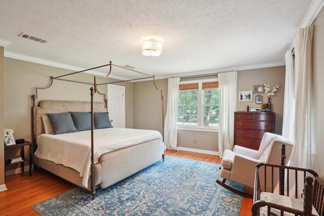 42 Riverdale Dr, Covington, LA 70433 - bedroom with wood finished floors, ornamental molding, a textured ceiling, and baseboards