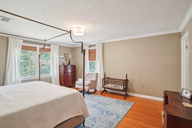 42 Riverdale Dr, Covington, LA 70433 - bedroom featuring ornamental molding, light wood-style floors, a textured ceiling, and baseboards