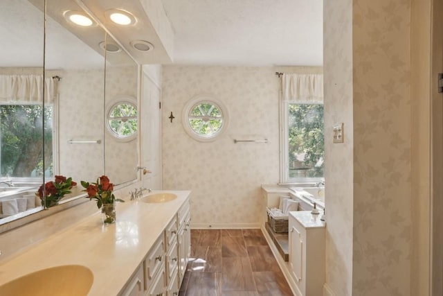 42 Riverdale Dr, Covington, LA 70433 - bathroom with wallpapered walls, baseboards, double vanity, and a tub