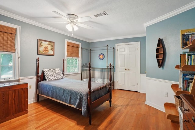 42 Riverdale Dr, Covington, LA 70433 - bedroom featuring wood finished floors, crown molding, a textured ceiling, a wainscoted wall, and a ceiling fan